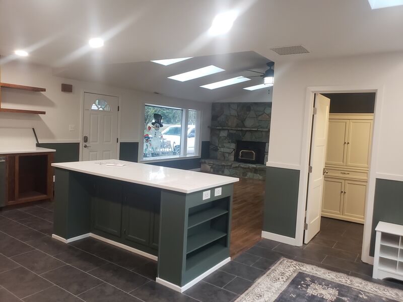 Completed kitchen remodel with green island by ArchAngel Construction Services