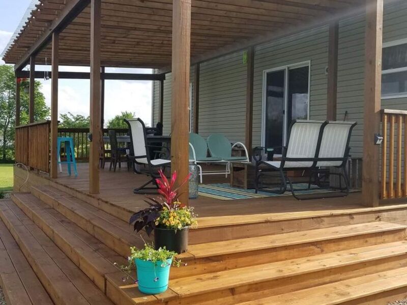 Pergola-covered deck with seating area by ArchAngel Construction Services